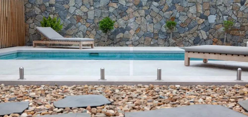 Décorer le contour d'une piscine avec des galets